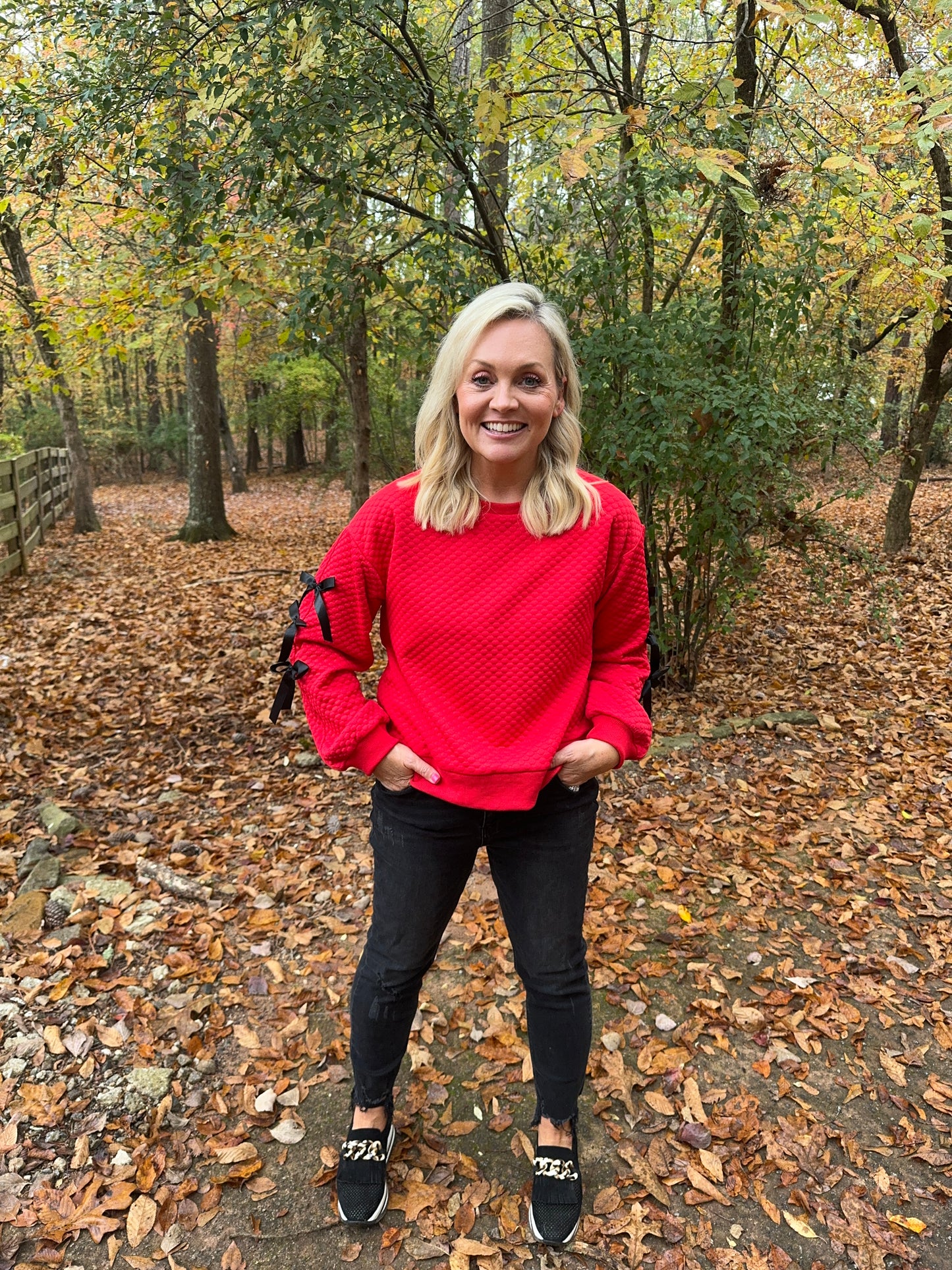 Embossed textured red top with black bows marked down