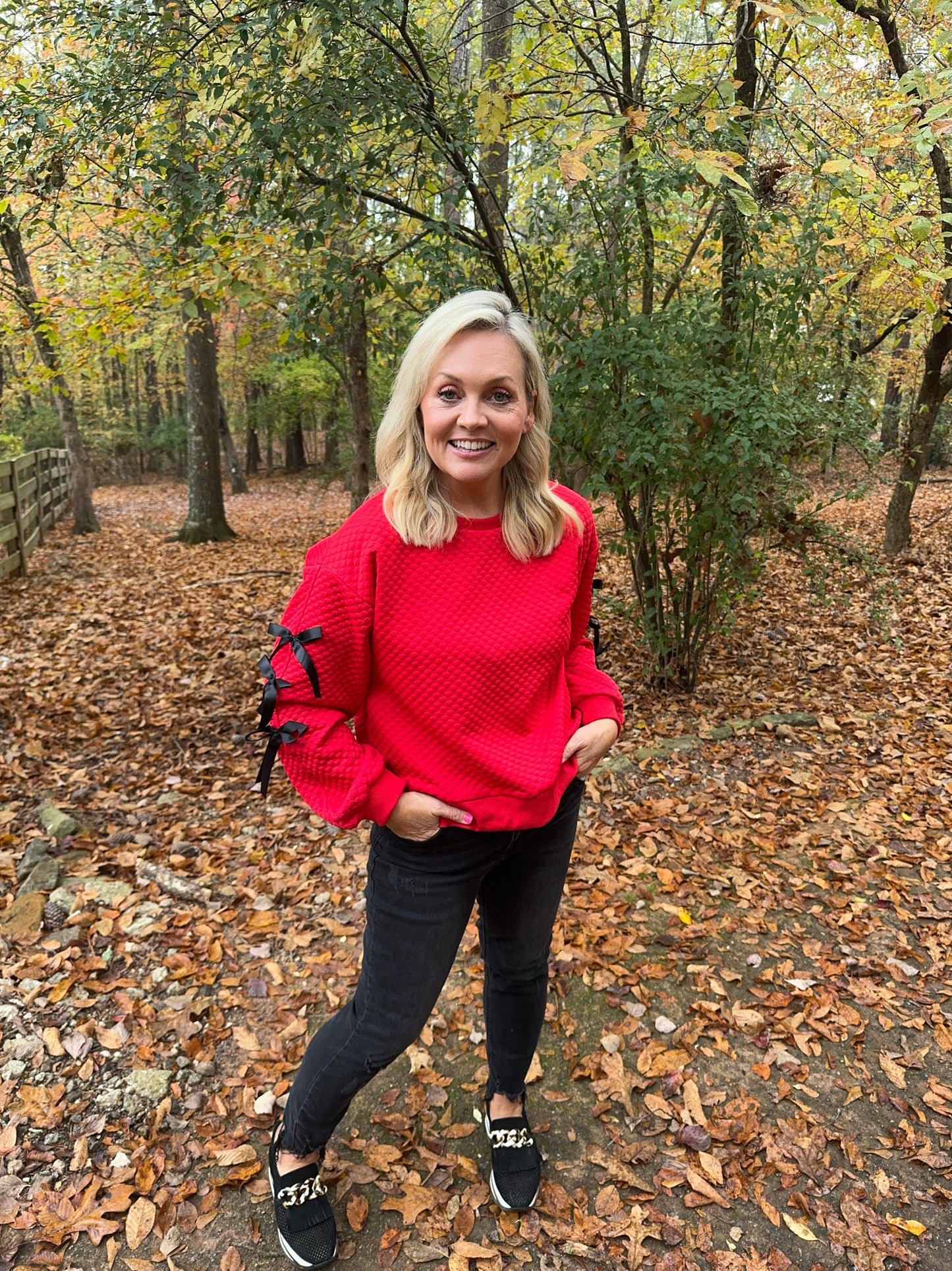 Embossed textured red top with black bows marked down