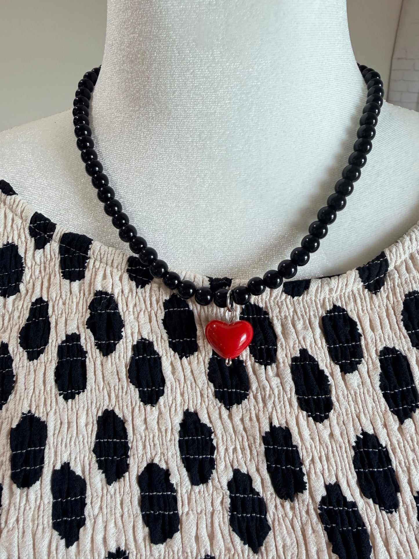 Black beaded necklace with red heart