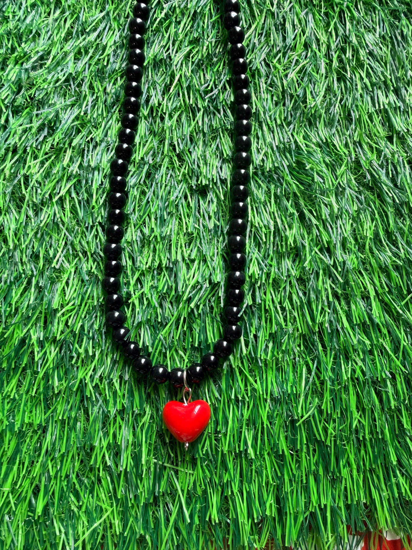 Black beaded necklace with red heart